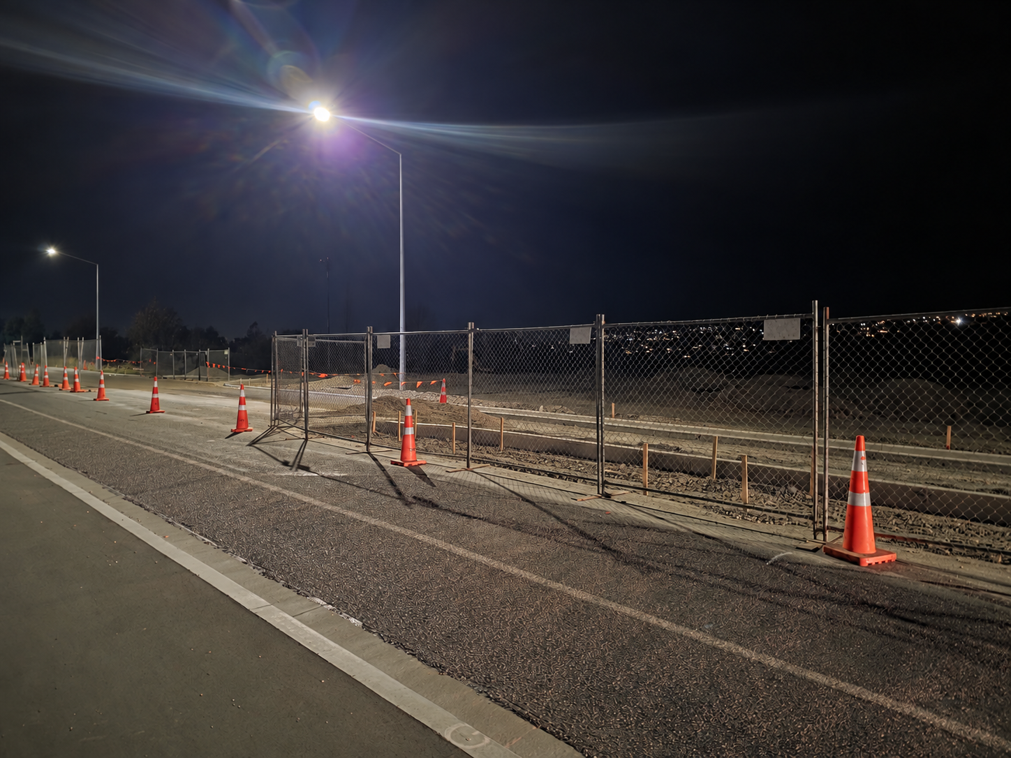 Night worksite protected with temporary fencing, lighting and traffic management